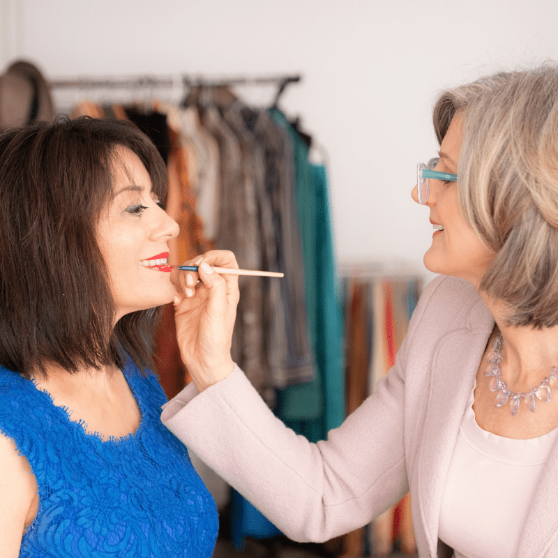 Applying lipstick to a woman